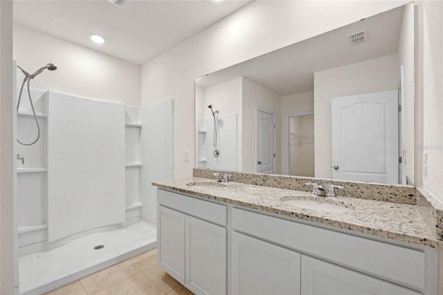 bathroom with vanity, a shower, and tile patterned flooring