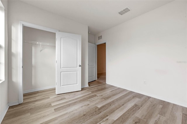 unfurnished bedroom featuring light hardwood / wood-style flooring and a closet