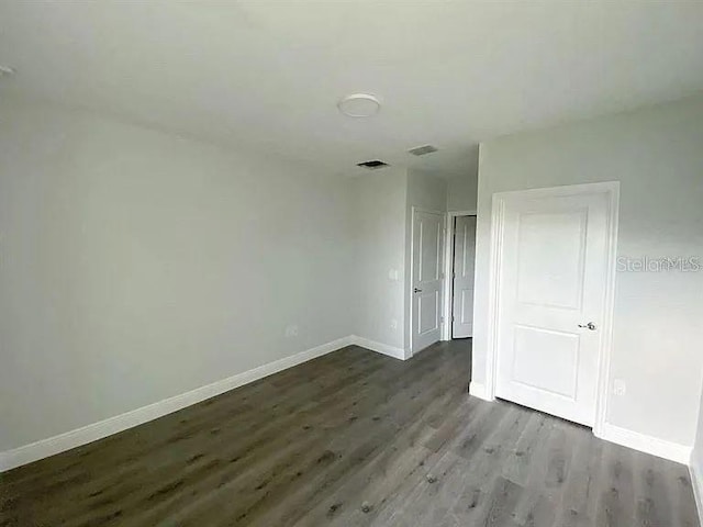 unfurnished room featuring dark wood-type flooring