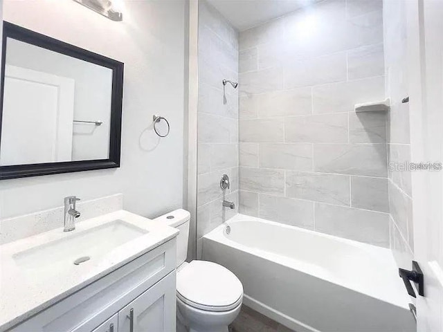 full bathroom featuring vanity, toilet, and tiled shower / bath