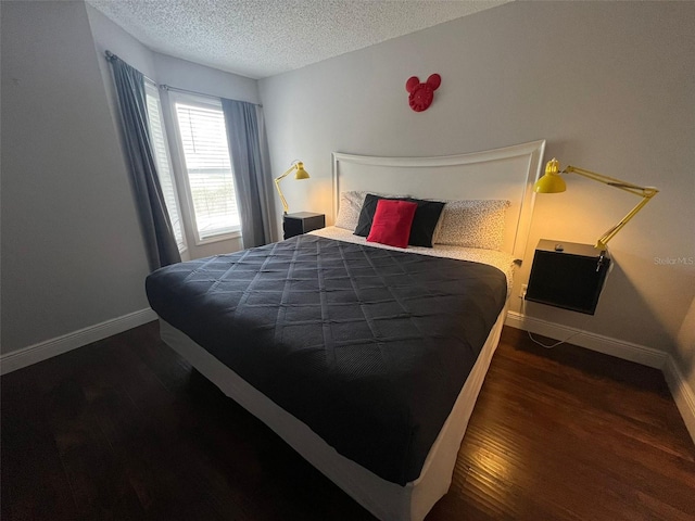 bedroom with a textured ceiling and dark hardwood / wood-style floors