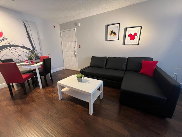 living room featuring a textured ceiling and dark hardwood / wood-style floors