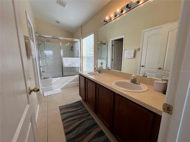 bathroom with combined bath / shower with glass door, tile patterned floors, lofted ceiling, vanity, and a textured ceiling