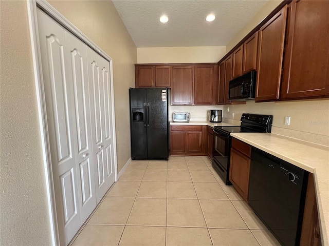 kitchen featuring light tile patterned flooring, black appliances, and a textured ceiling