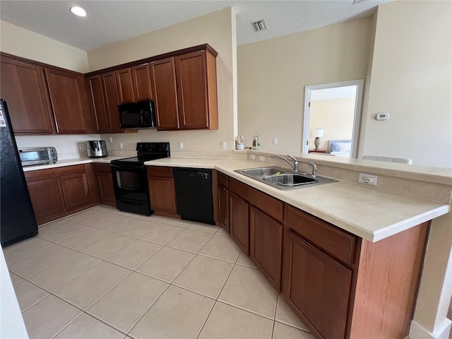 kitchen with sink, kitchen peninsula, a textured ceiling, and black appliances