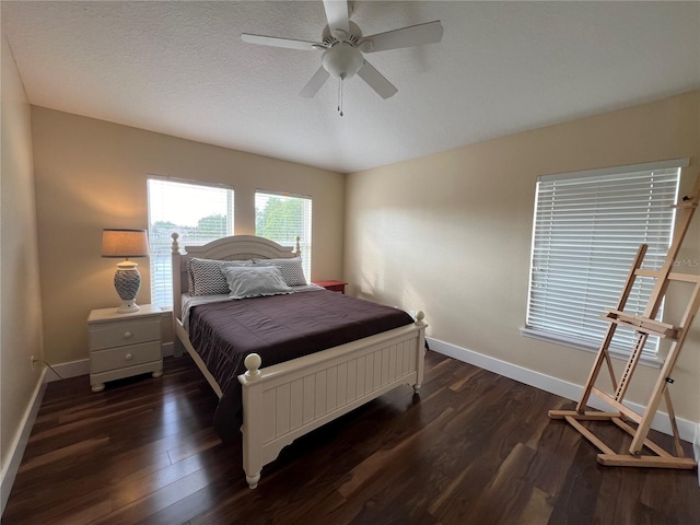 bedroom featuring ceiling fan, dark wood-type flooring, and a textured ceiling