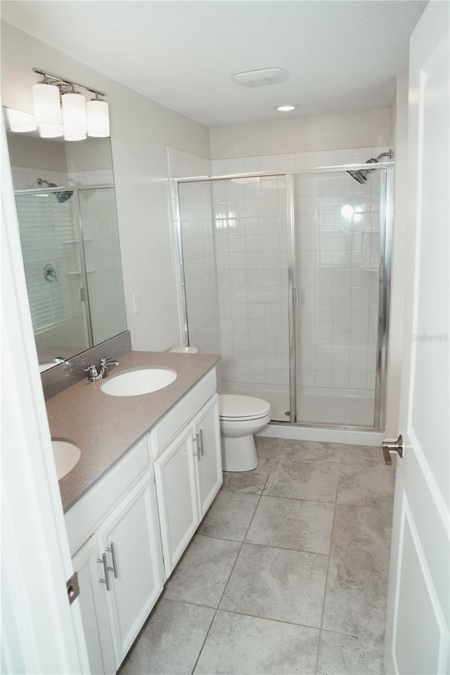 bathroom with vanity, toilet, and a shower with shower door