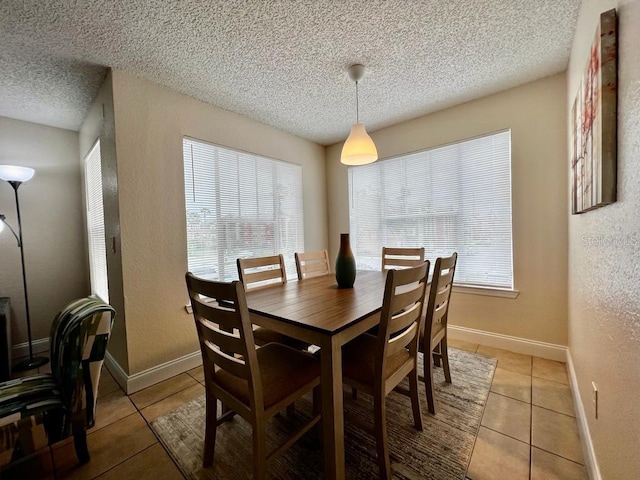 tiled dining room featuring a textured ceiling