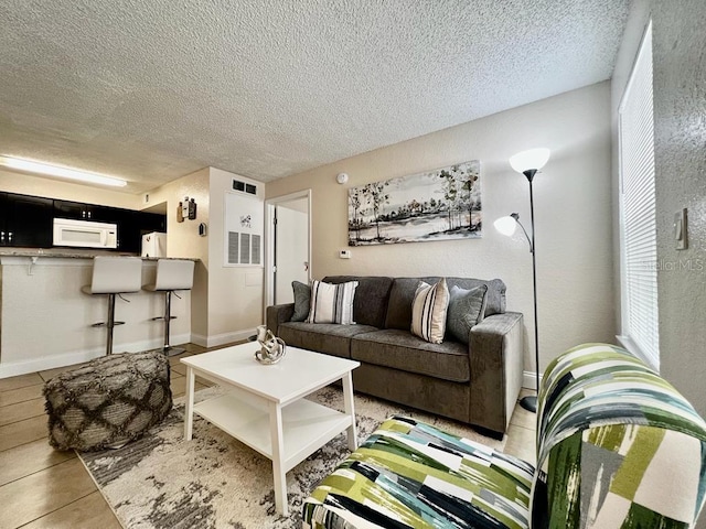 tiled living room featuring a textured ceiling