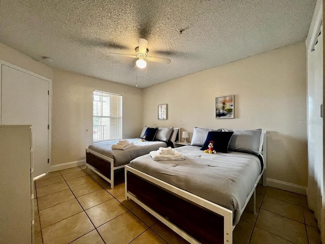 bedroom featuring light tile patterned floors, a textured ceiling, and ceiling fan