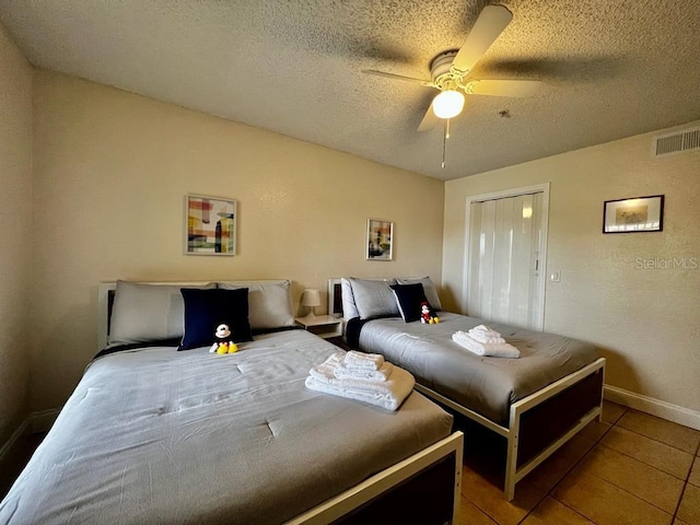 tiled bedroom featuring ceiling fan and a textured ceiling