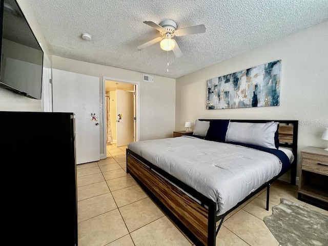 bedroom featuring light tile patterned floors, a textured ceiling, and ceiling fan