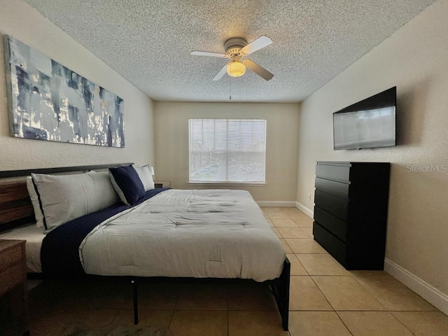 bedroom with light tile patterned flooring, ceiling fan, and a textured ceiling