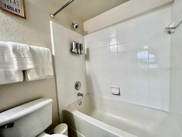 bathroom with tiled shower / bath and toilet