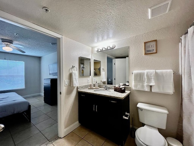 bathroom featuring ceiling fan, toilet, tile patterned floors, vanity, and a textured ceiling