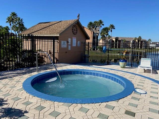 view of swimming pool with a community hot tub and a patio area