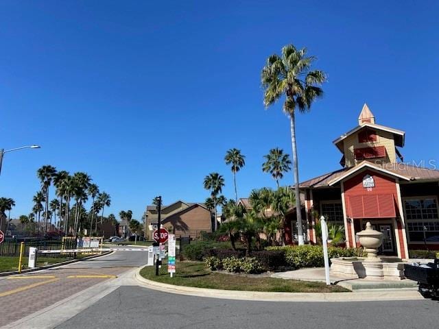 2210 Grand Cayman Ct Unit 1722, Kissimmee, FL 34741 - view of asphalt street with traffic signs, street lights, curbs, and a gated entry