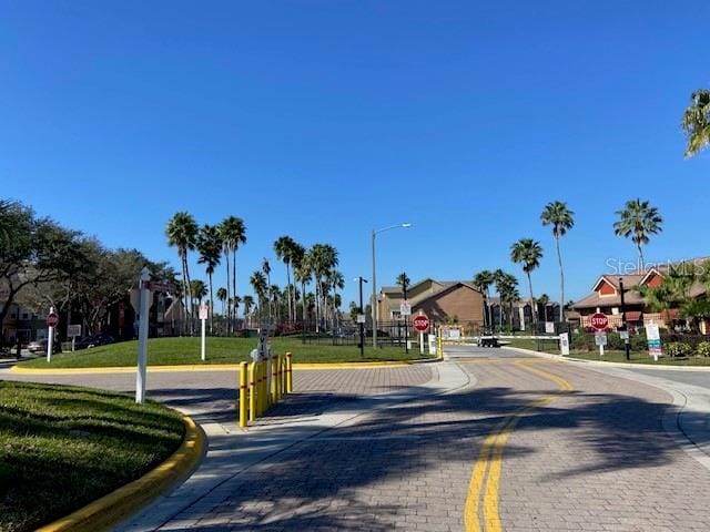 2210 Grand Cayman Ct Unit 1722, Kissimmee, FL 34741 - view of decorative road featuring traffic signs, curbs, a residential view, and street lighting