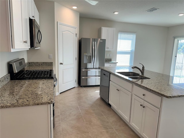 kitchen with white cabinets, stainless steel appliances, sink, and a wealth of natural light