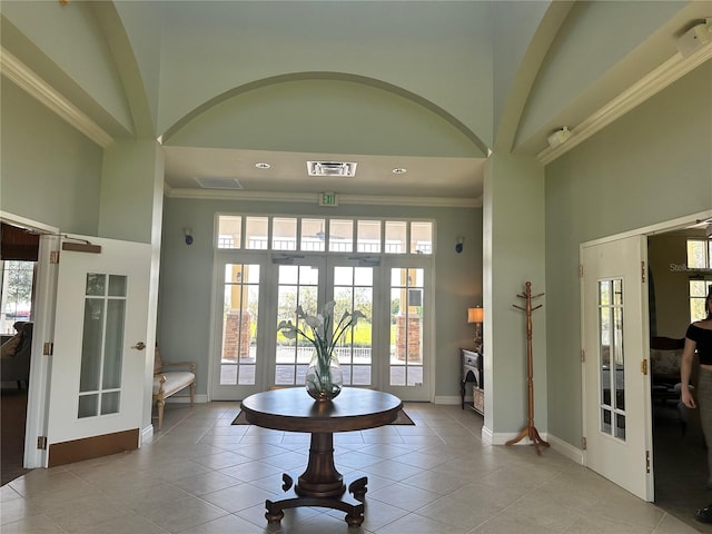 tiled foyer entrance featuring french doors, ornamental molding, and a wealth of natural light