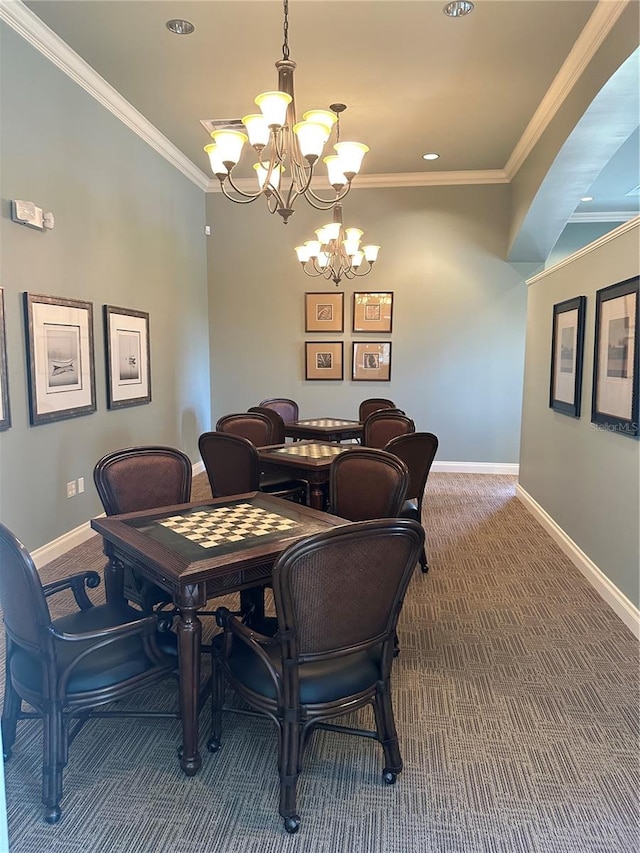 dining area with ornamental molding, carpet floors, and an inviting chandelier