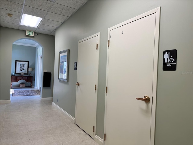 corridor featuring a paneled ceiling and light tile patterned floors