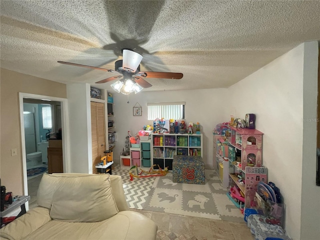 game room featuring ceiling fan and a textured ceiling