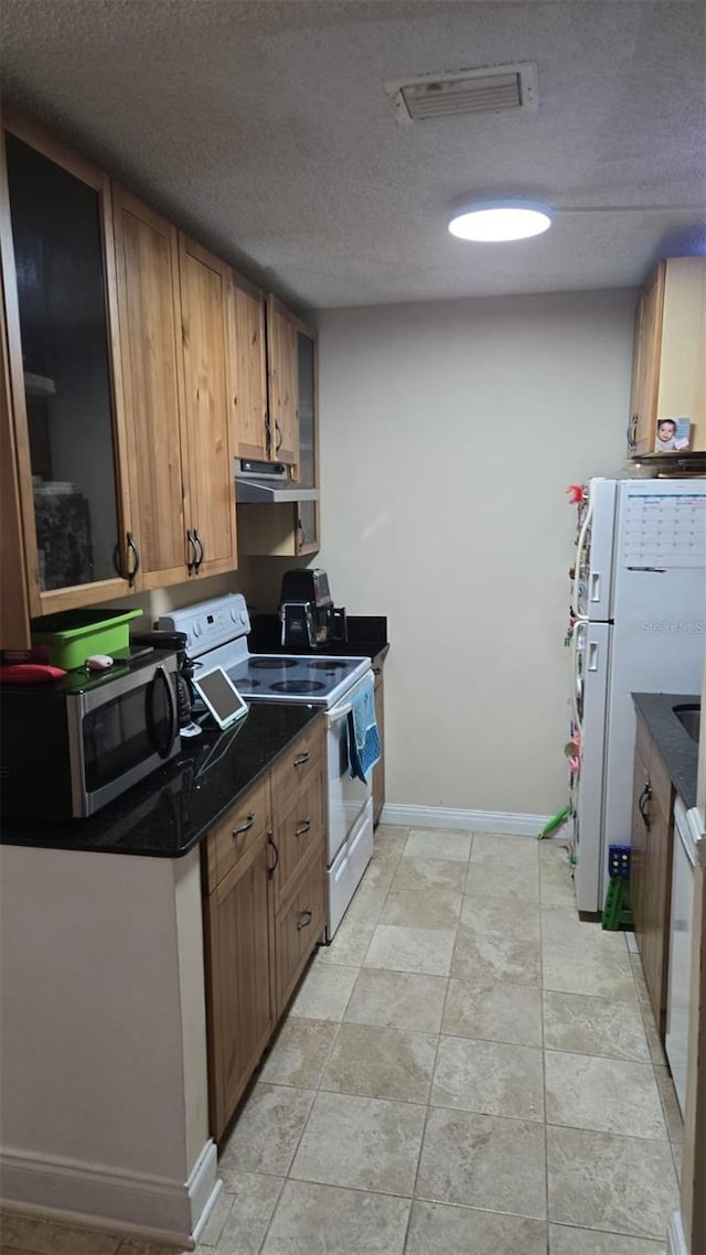 kitchen with white appliances and a textured ceiling