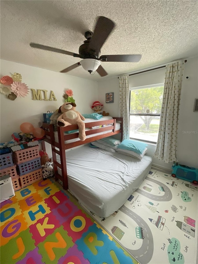 bedroom with a textured ceiling and ceiling fan