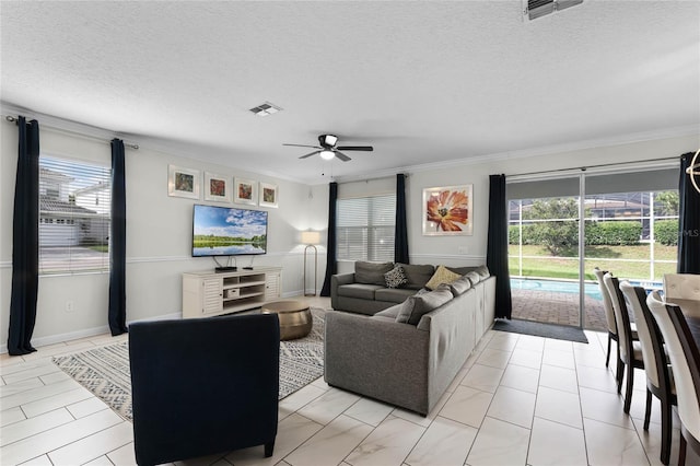 living room featuring ceiling fan, a textured ceiling, crown molding, and light tile patterned floors