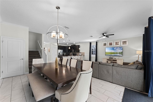 dining space with ceiling fan with notable chandelier and ornamental molding