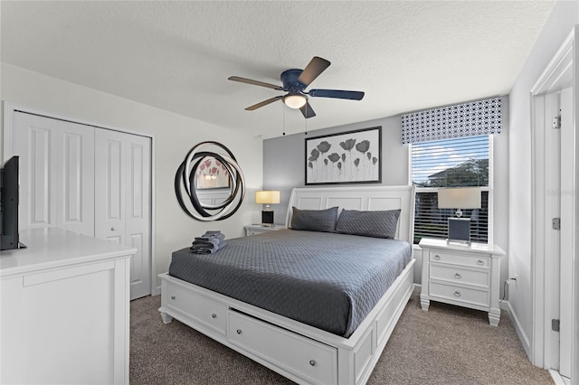 carpeted bedroom featuring ceiling fan, a textured ceiling, and a closet