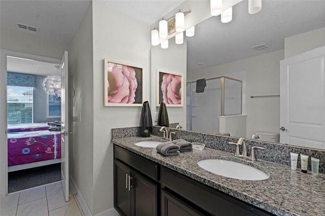 bathroom featuring toilet, tile patterned flooring, an enclosed shower, and vanity