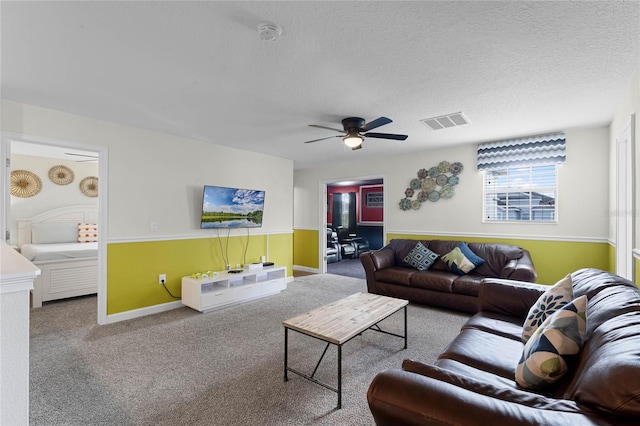 carpeted living room with ceiling fan and a textured ceiling