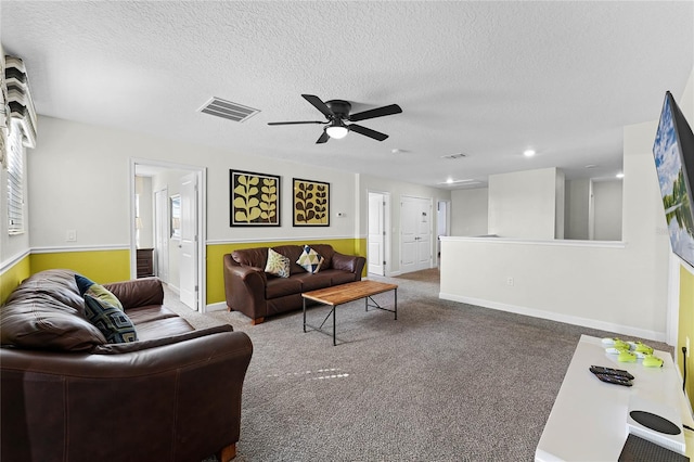 living room featuring a textured ceiling, ceiling fan, and carpet flooring