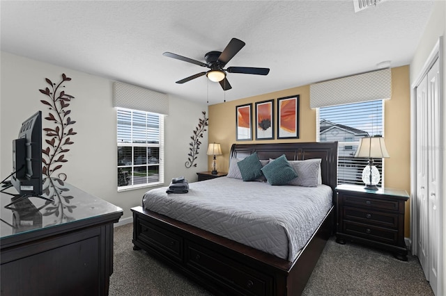 carpeted bedroom with ceiling fan, a closet, and multiple windows