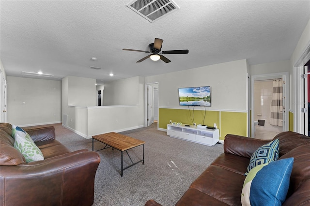 living room featuring ceiling fan, a textured ceiling, and carpet