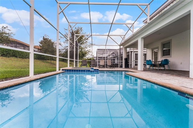 view of pool with a yard, glass enclosure, and a patio area