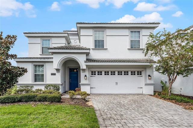 mediterranean / spanish house featuring a front yard and a garage