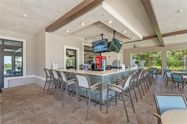 kitchen featuring kitchen peninsula, beamed ceiling, and a kitchen breakfast bar