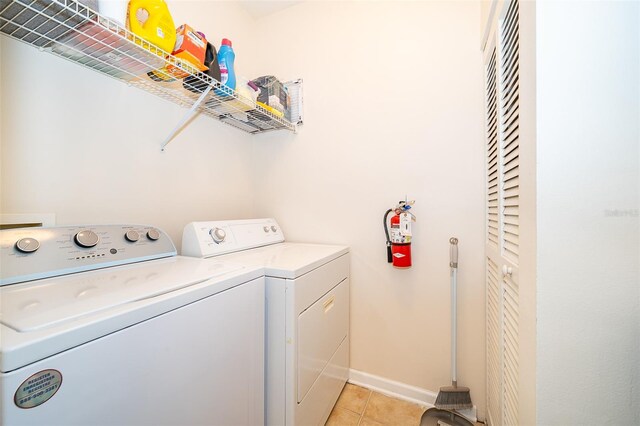 washroom with washer and dryer and light tile patterned floors