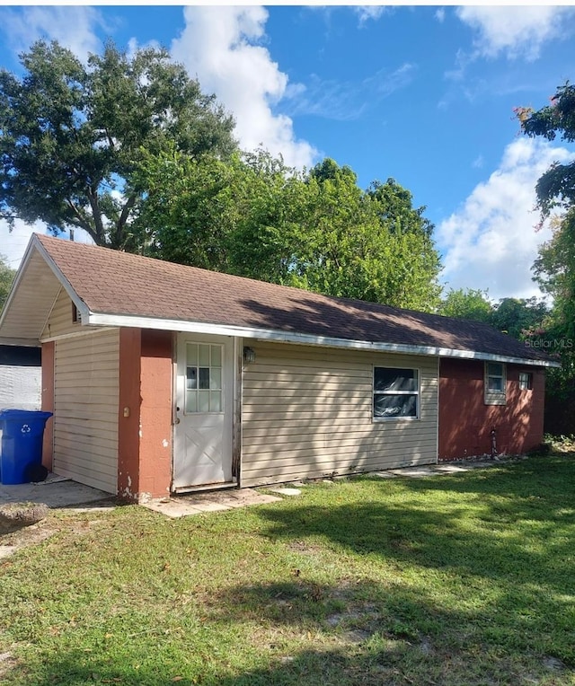 rear view of house featuring a yard