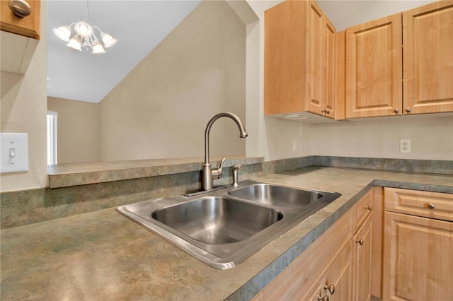 kitchen featuring lofted ceiling, light brown cabinetry, a chandelier, and sink