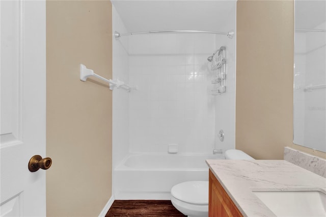 full bathroom featuring hardwood / wood-style flooring, vanity, tiled shower / bath, and toilet