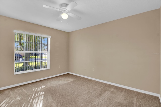 carpeted spare room featuring ceiling fan