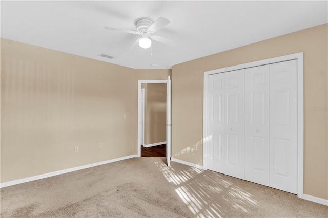 unfurnished bedroom with carpet, ceiling fan, and a closet