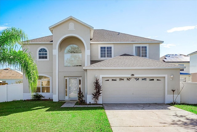 view of front of home featuring stucco siding, roof with shingles, a front yard, fence, and an attached garage