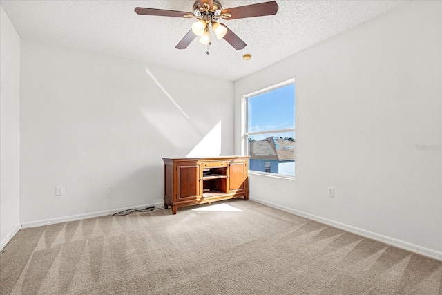 empty room featuring light carpet, a textured ceiling, and ceiling fan