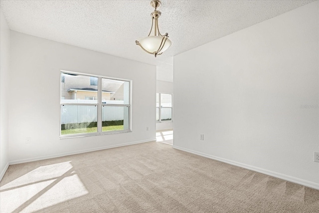 carpeted empty room with a textured ceiling