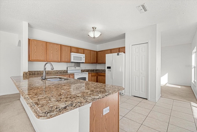 kitchen with white appliances, a textured ceiling, light carpet, sink, and kitchen peninsula